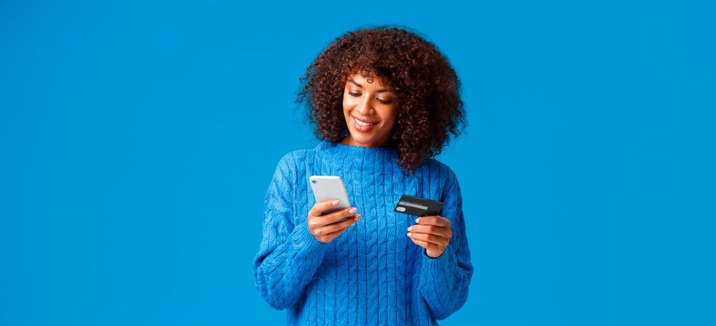 Mujer cliente omnichannel con una tarjeta de crédito a punto de hacer una compra en línea